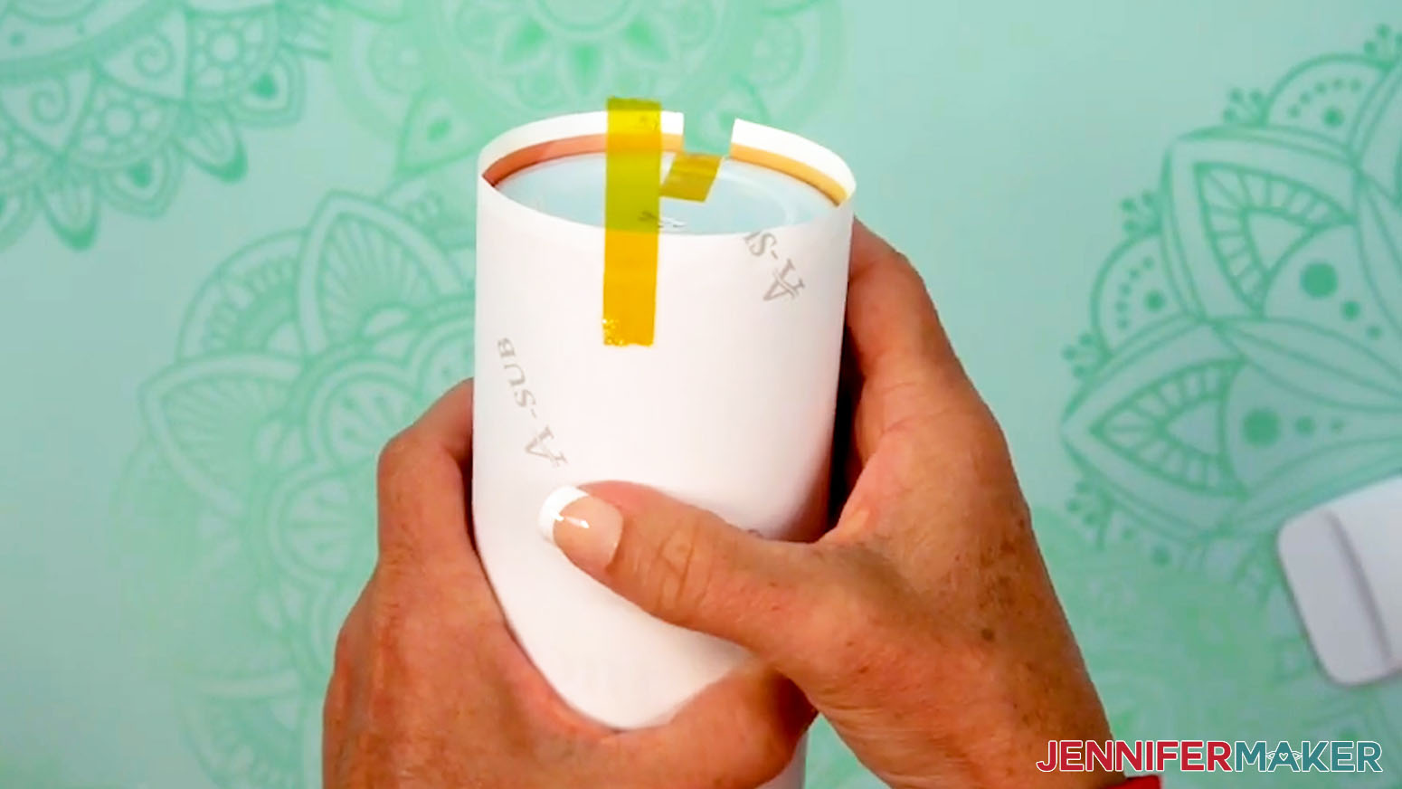 Place a second piece of tape on the bottom of the sublimation design tumbler directly across from the first.