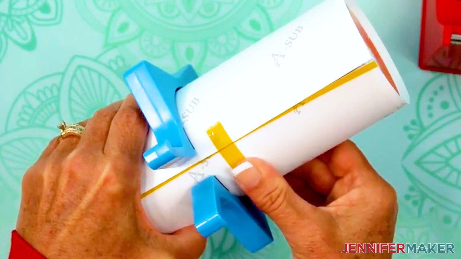 Press the first piece of tape into place across the seam of the sublimation design tumbler.
