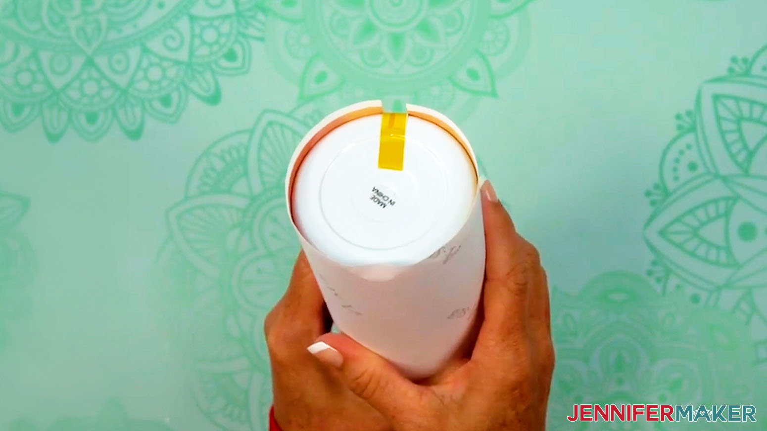 Secure the piece of tape to the bottom of the sublimation design tumbler.
