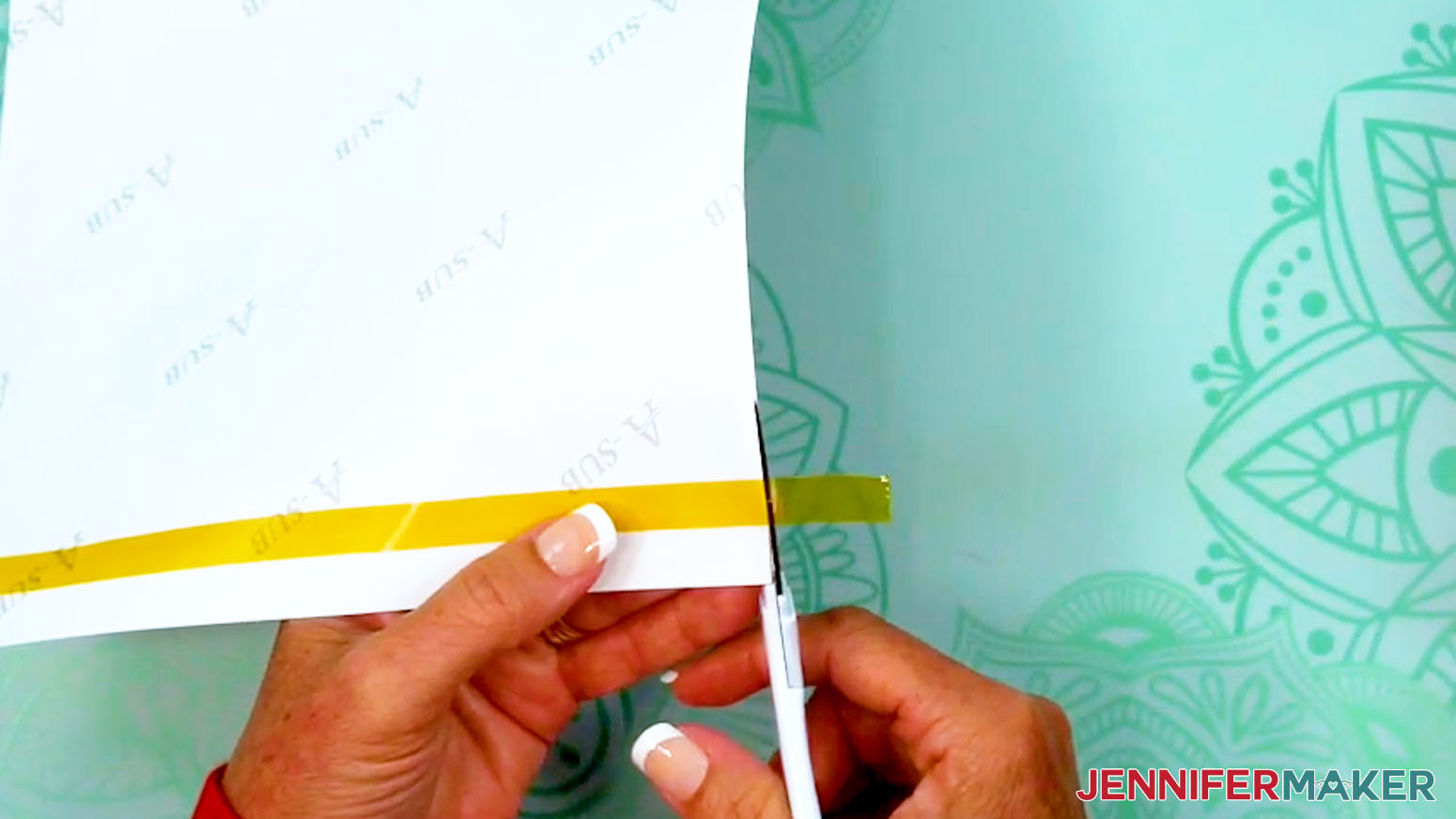 Trim the tape that drapes over the edges of the sublimation tumbler design.