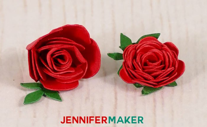 Closeup of two miniature paper roses made with red and green cardstock