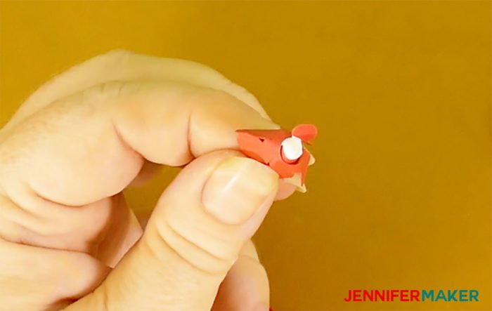 Putting glue in the base of the rolled miniature paper rose