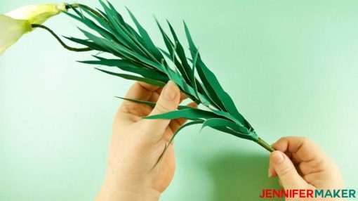 Wrapping leaves around the stems of the paper lily flowers