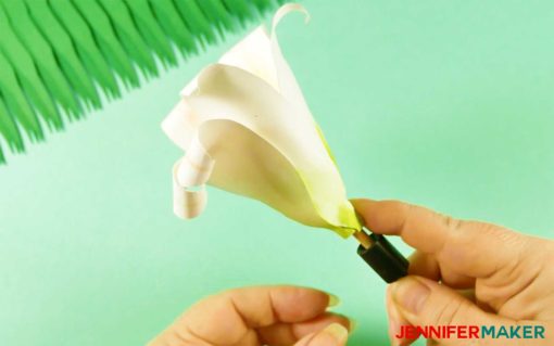 Rolling up the paper lily flower petals using a quilling tool