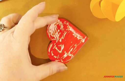 Gluing one side of one folded heart to make the pop-up heart card