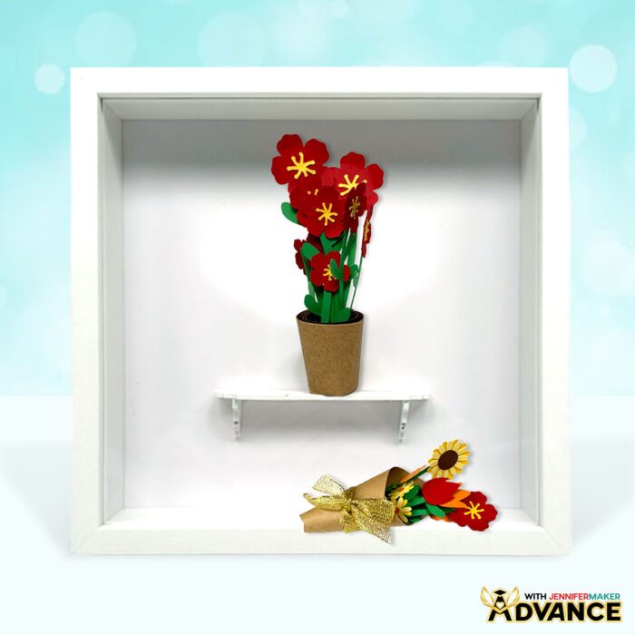 Two mini paper flower arrangements on display in a shadow box in a paper pot and a wrapped bouquet, both from JenniferMaker's Mini Paper Flower Tutorial and Advance tutorial