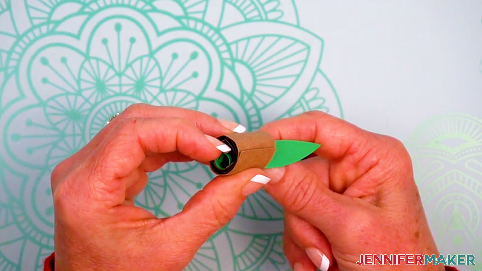 Press and hold the flower stem in place along the back of the pot to adhere the glue.