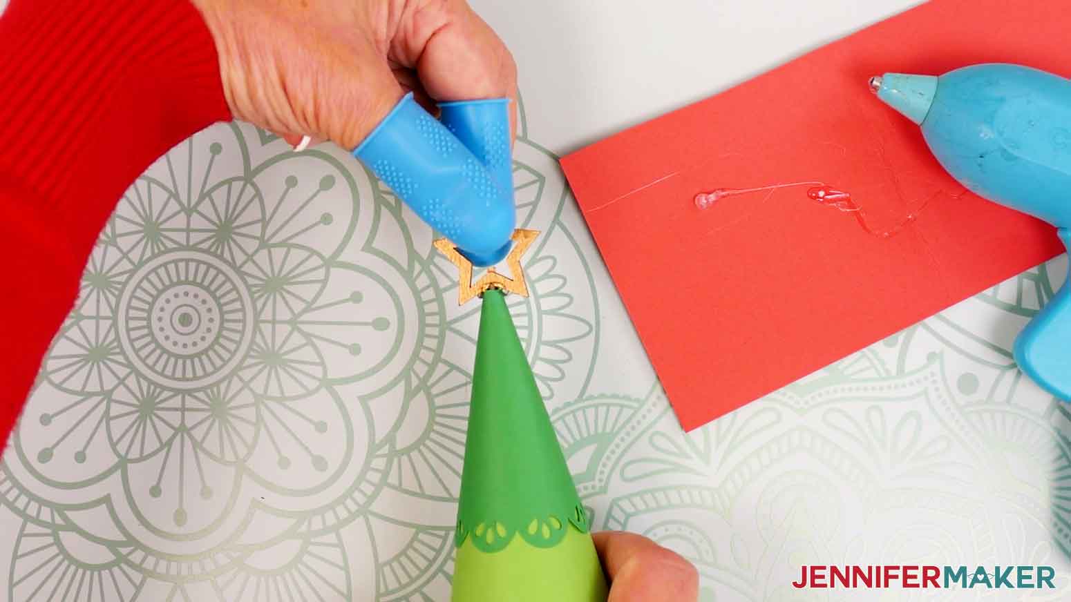 Press and hold the bamboo star in place at the top of the advent calendar tree until the glue sets.