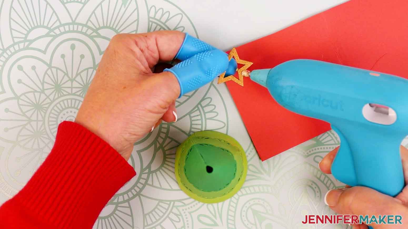 Hold the bamboo star between your protected fingers and add hot glue around the stick at the base of the star.