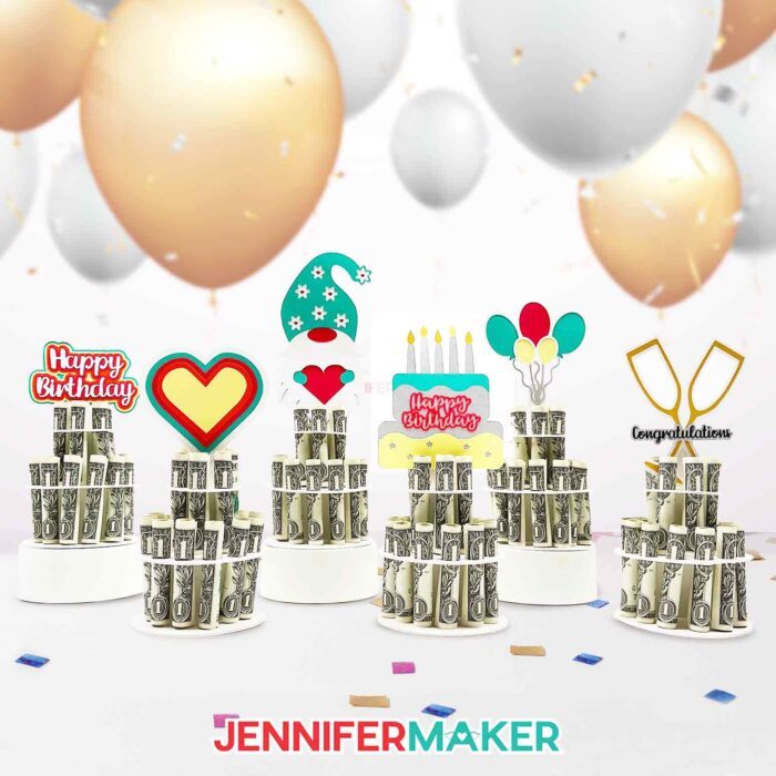 Six colorful paper money cake decorations, each holding rolled dollar bills in a column, topped with a multicolor Happy Birthday sign, a heart, a cute gnome, birthday cake, balloons, and crossed champagne flutes, made using JenniferMaker SVG files.