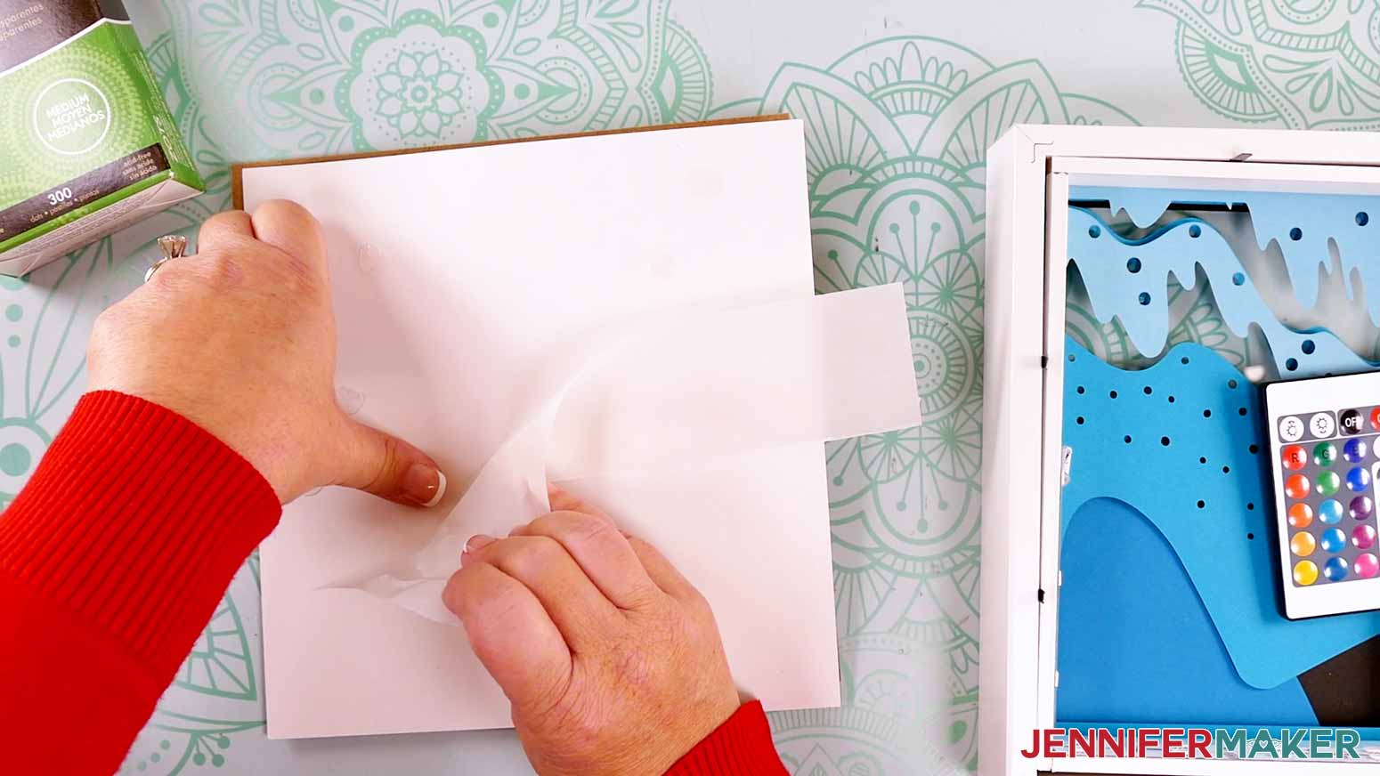 Adding glue dots to the layers to make a Northern Lights Shadow Box