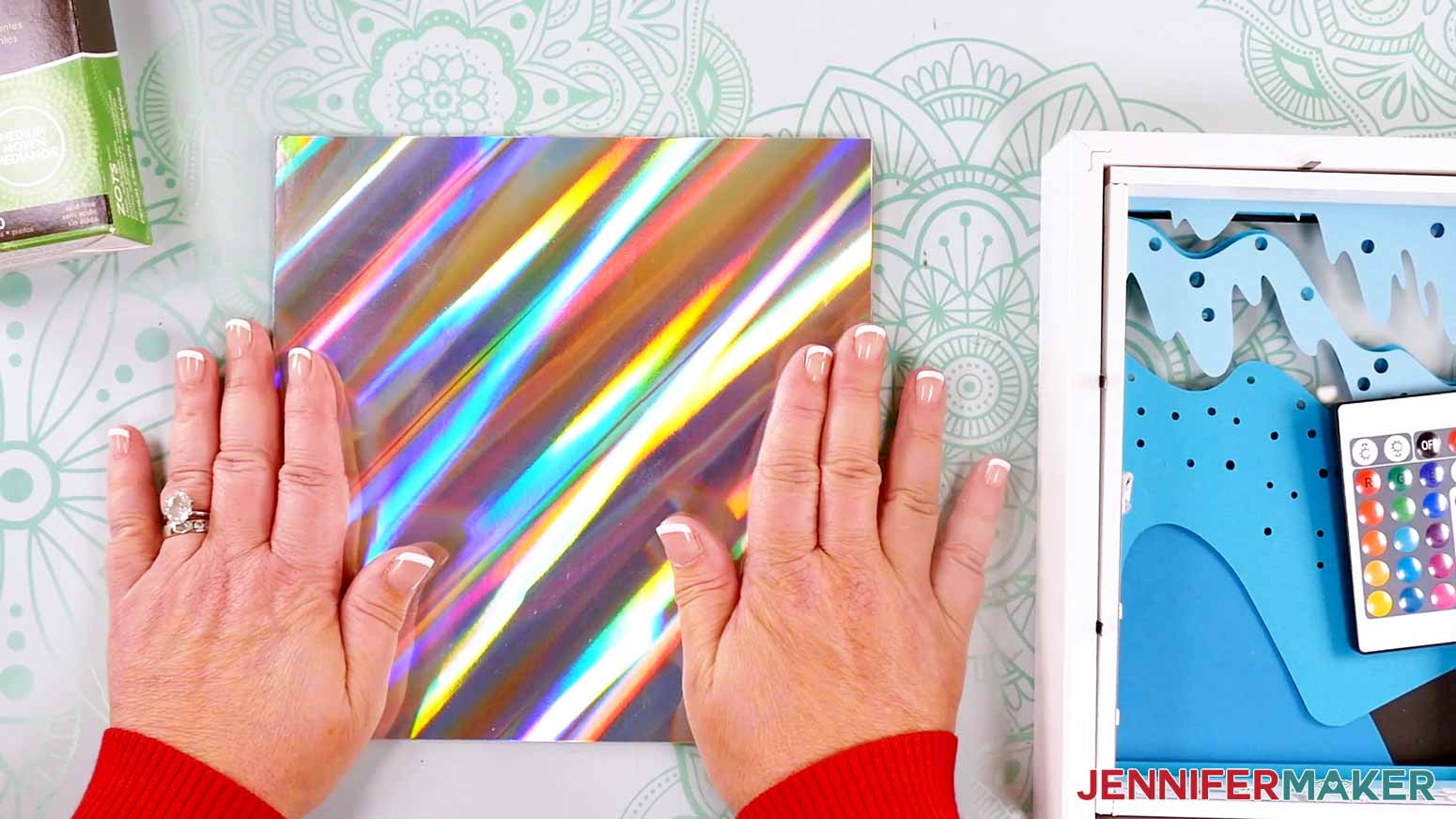 Adhering the holographic cardstock to the frame backer to make a Northern Lights Shadow Box