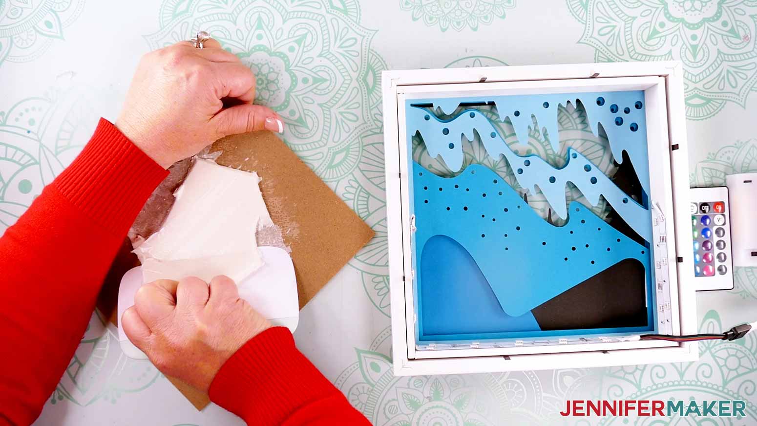 Using a scraper tool to scrape the foam off of the frame backer to make a Northern Lights Shadow Box