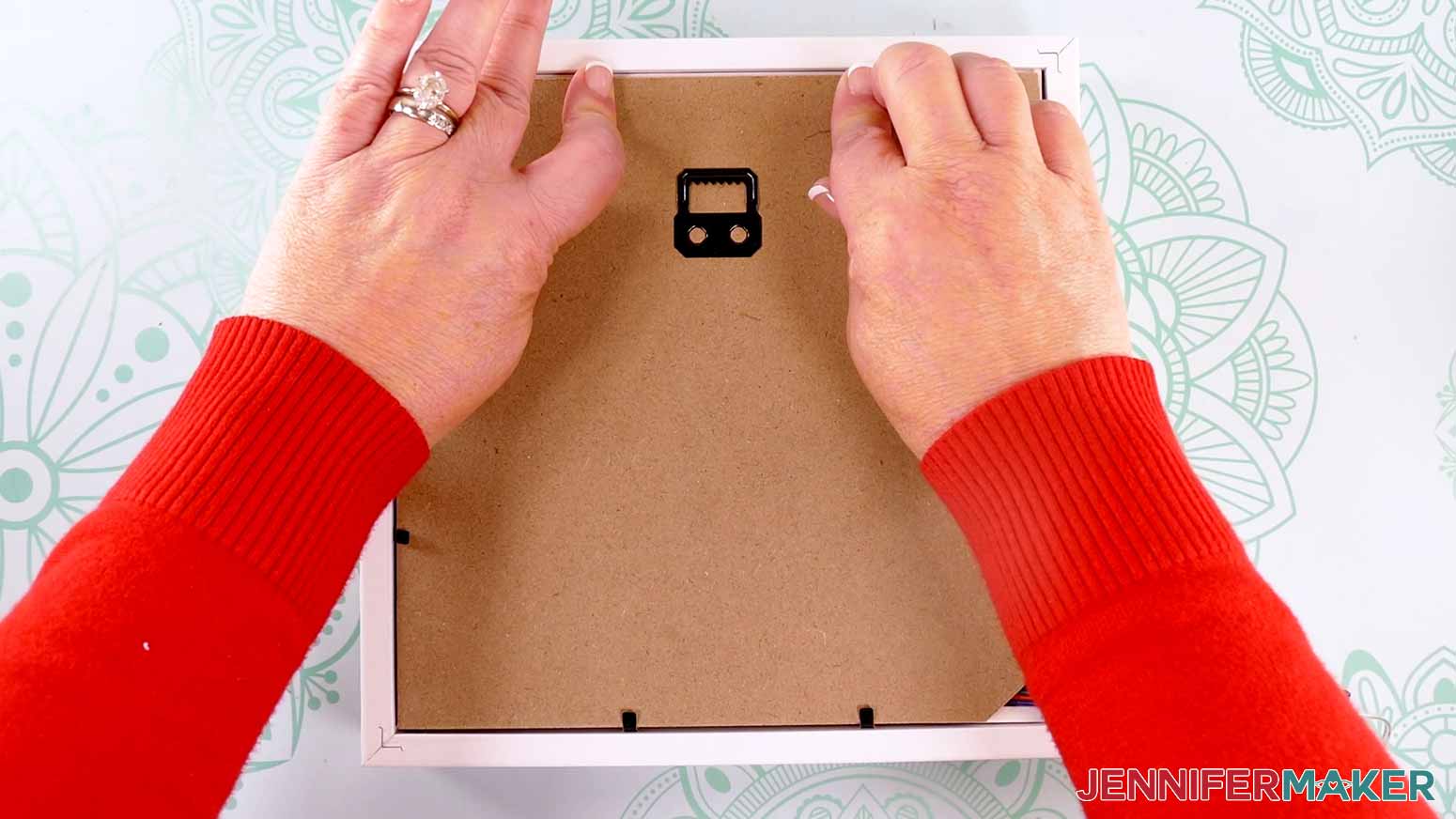 Securing the tabs on the back of the frame to make a Northern Lights Shadow Box