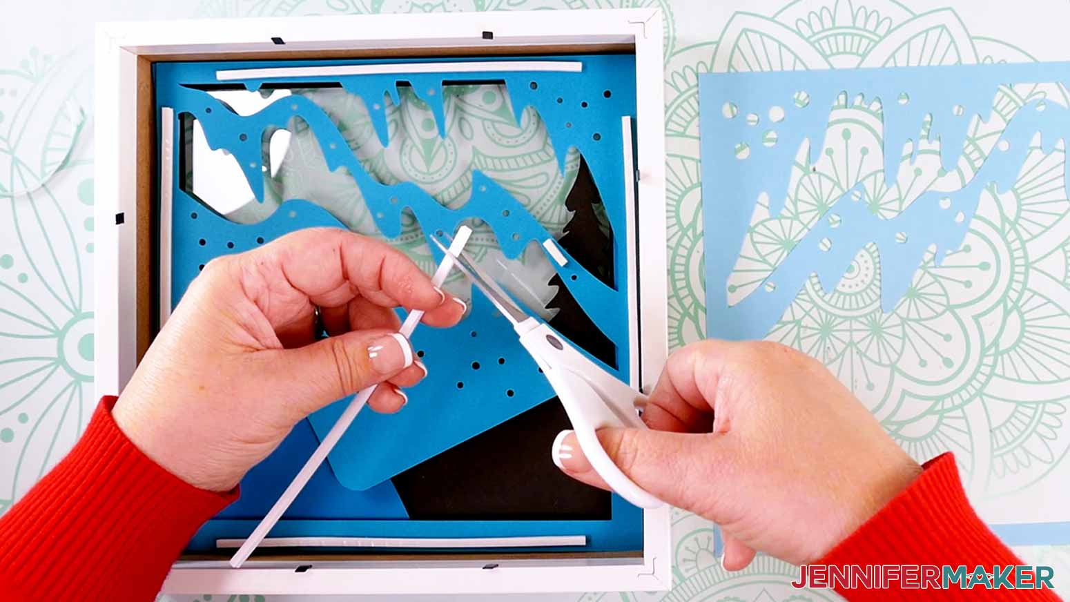 Trimming adhesive foam tape to the desired size adhere the layers in a customized Northern Lights Shadow Box
