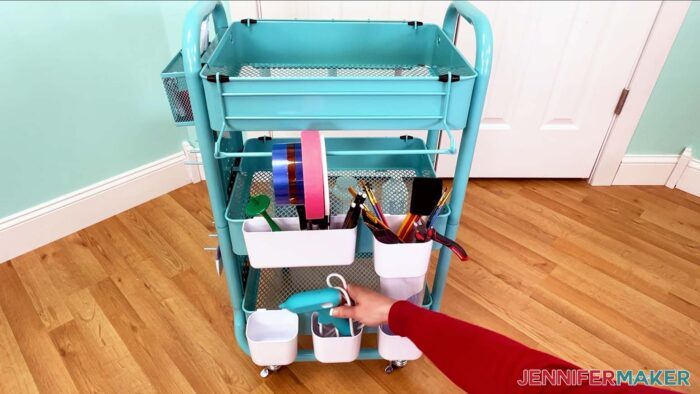 The glue gun is placed in one of the small bins on the craft cart.