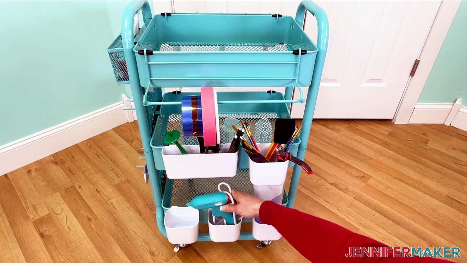 The glue gun is placed in one of the small bins on the craft cart.