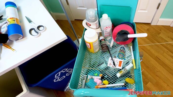 Removing scissors and other items from the top shelf of the messy craft cart.