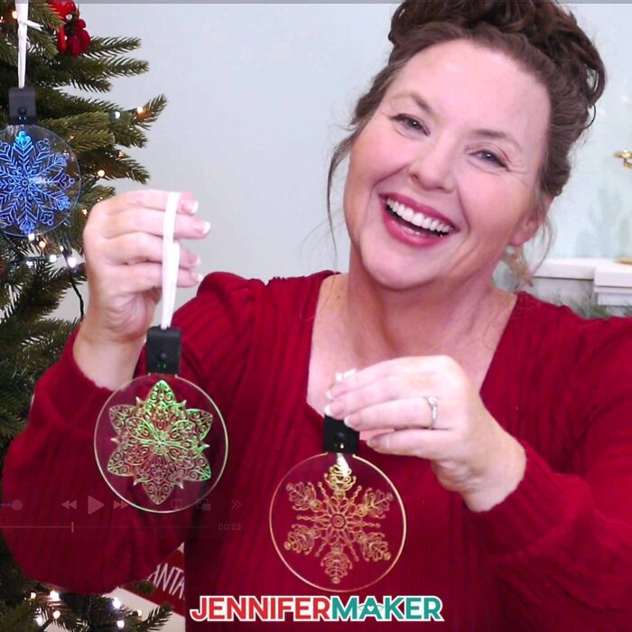 Jennifer Maker smiles, showing off two Acrylic Engraving ornaments she made with her Cricut