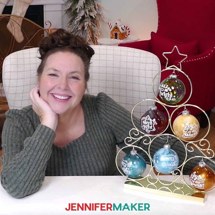 Jennifer shows off six alcohol ink ornaments hanging on a metal tree display.