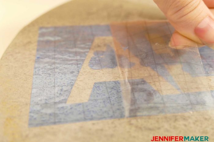 Peeling the transfer tape off the stencil on the stepping stone