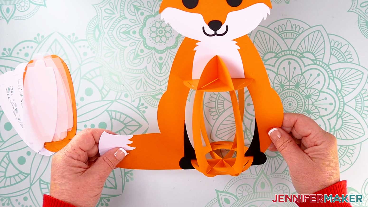 Insert the fox lantern's bottom base piece&rsquo;s six outer slits into the three frame pieces&rsquo; bottom slits.