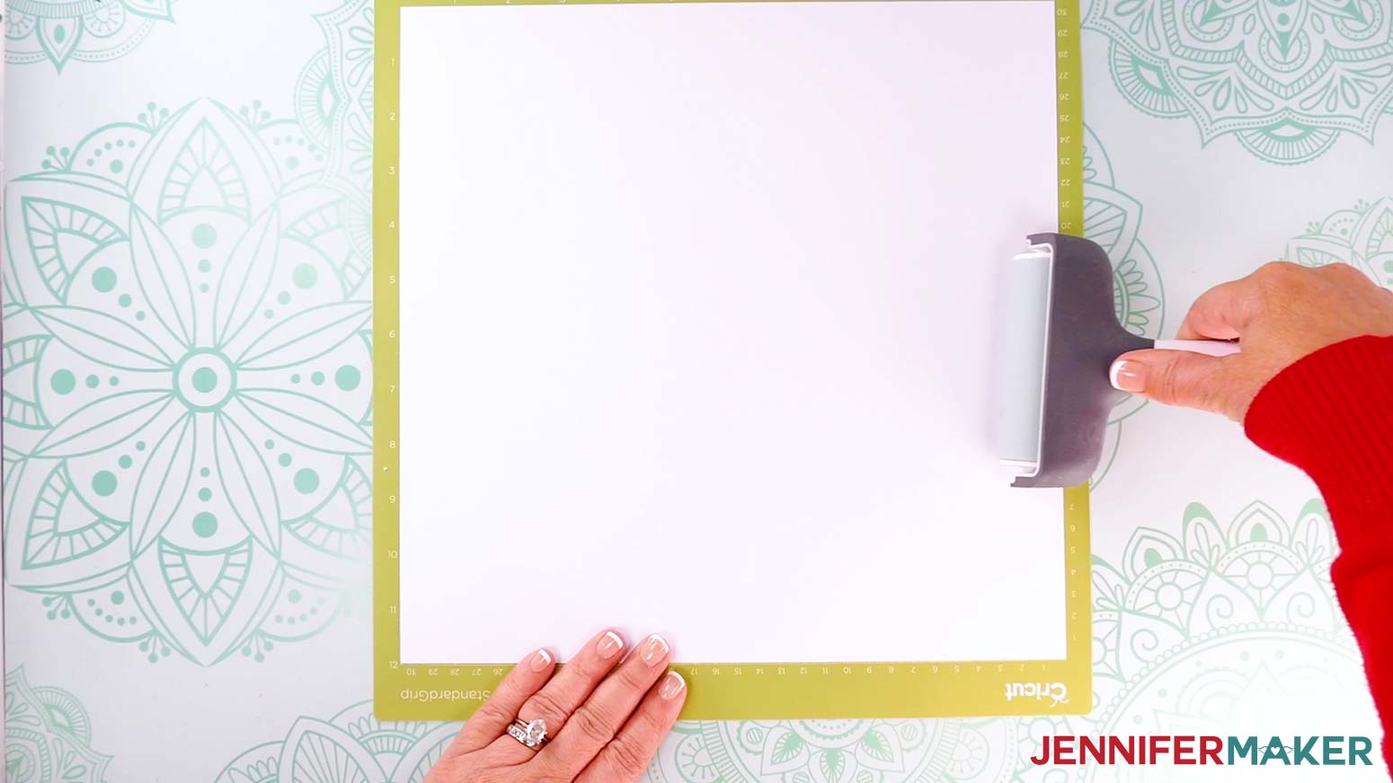 Use a brayer to smooth white cardstock on a green machine mat.