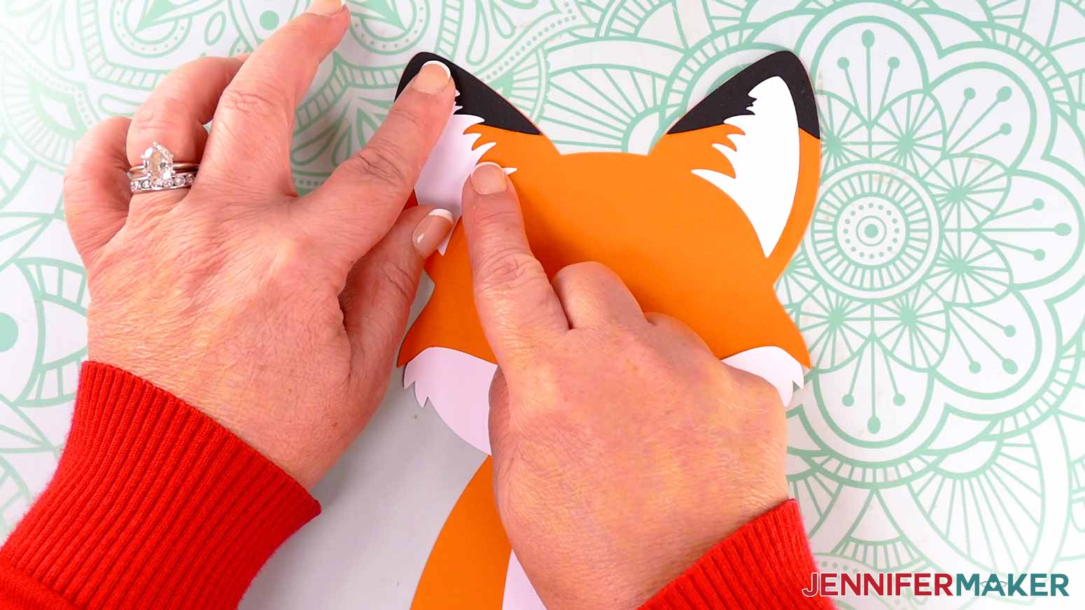 Adhere the fox lantern's inner ear fur piece in the center of the frame&rsquo;s ear.