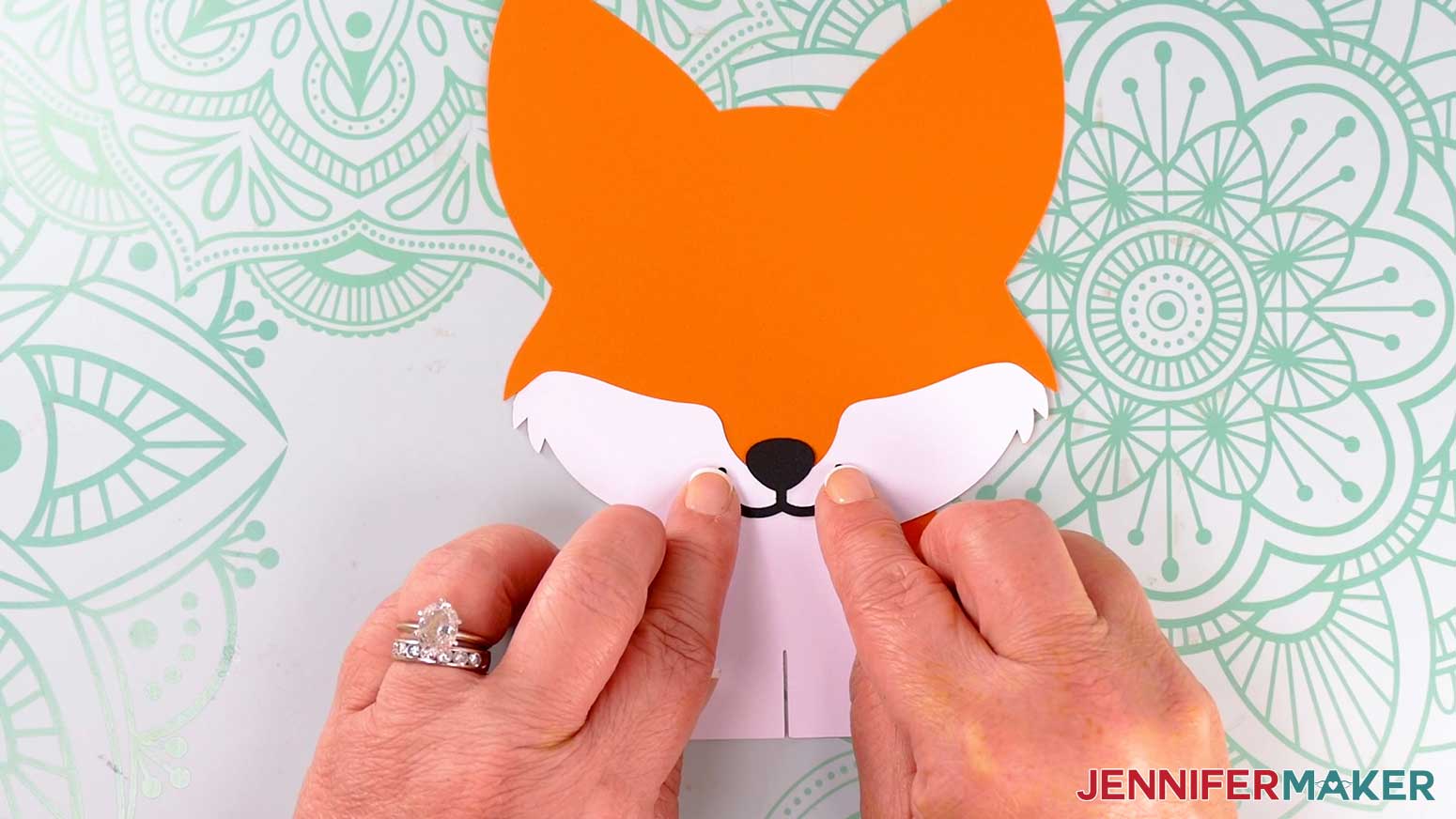 Adhere the fox lantern's mouth piece so the nose is mostly on the orange body frame and the mouth is on top of the white chest piece.