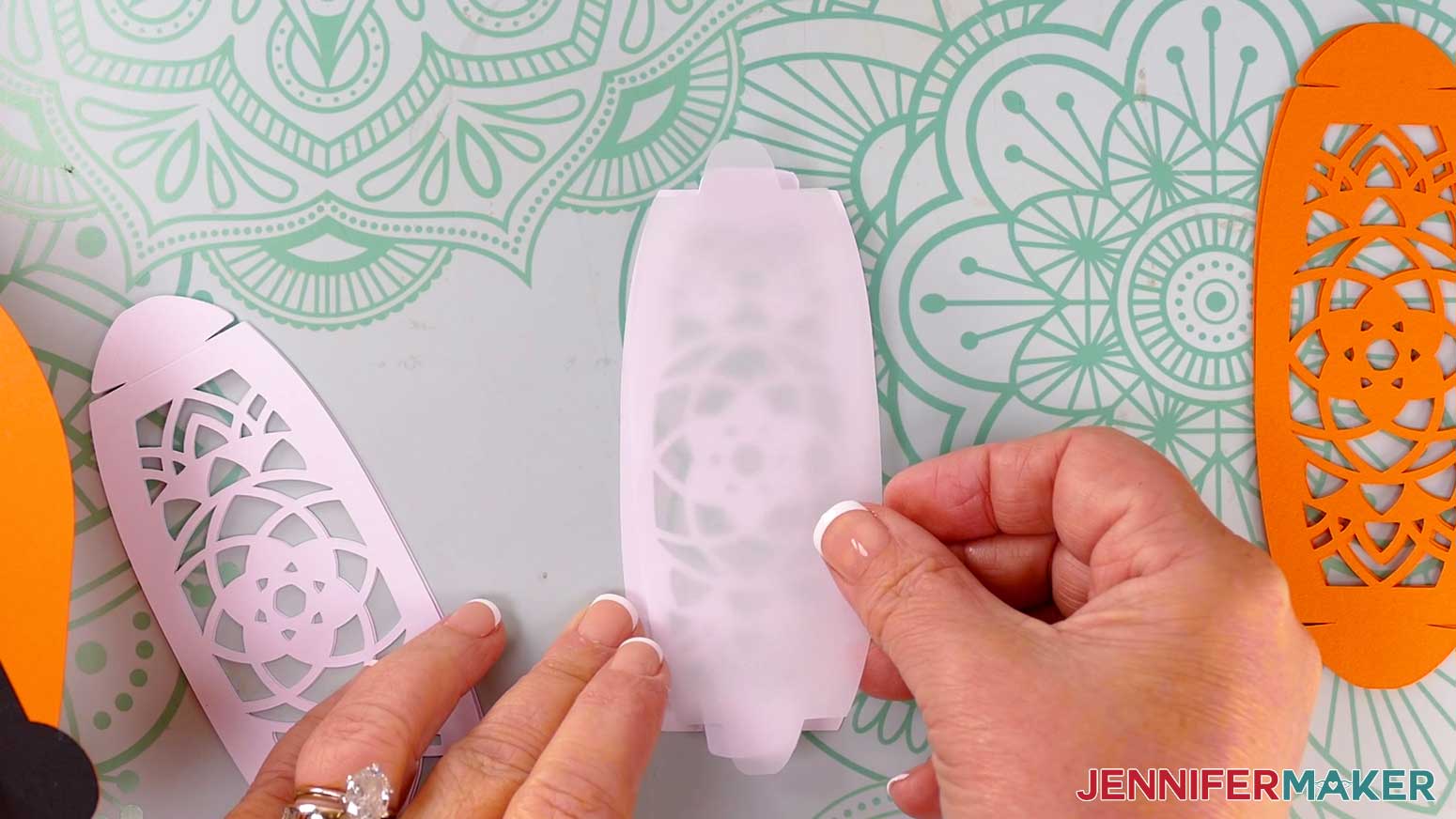 Insert a vellum diffuser piece onto the back of a folded fox lantern panel, using the wings to hold it in place.