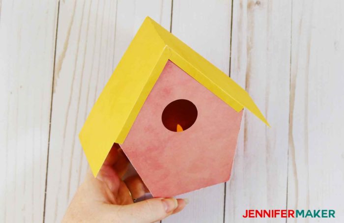 A yellow paper roof on a pink paper birdhouse