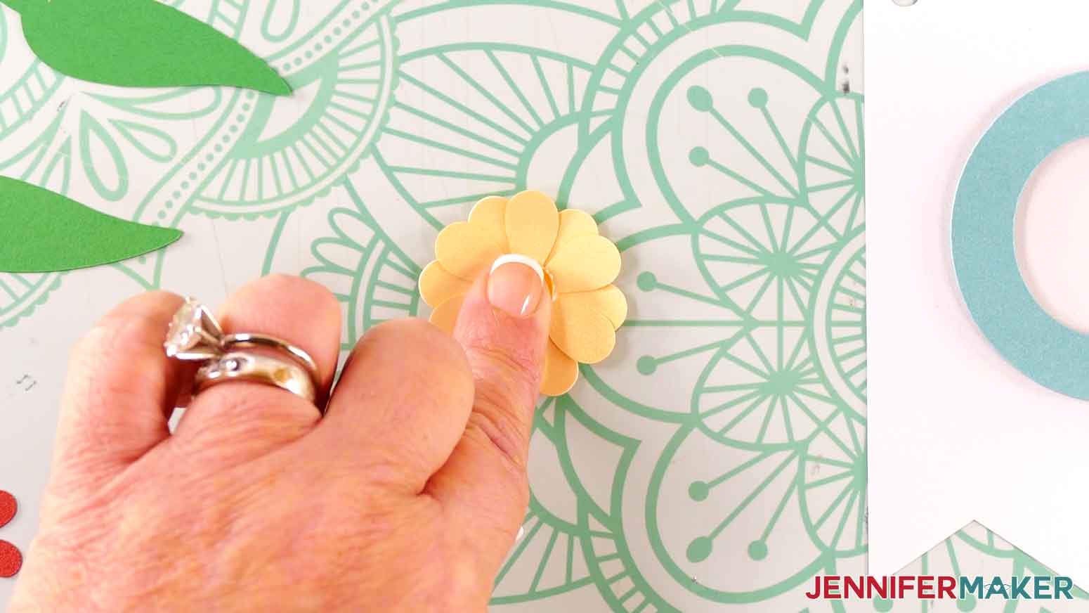Apply glue to the back of the small circle and press it to the center of the flower.