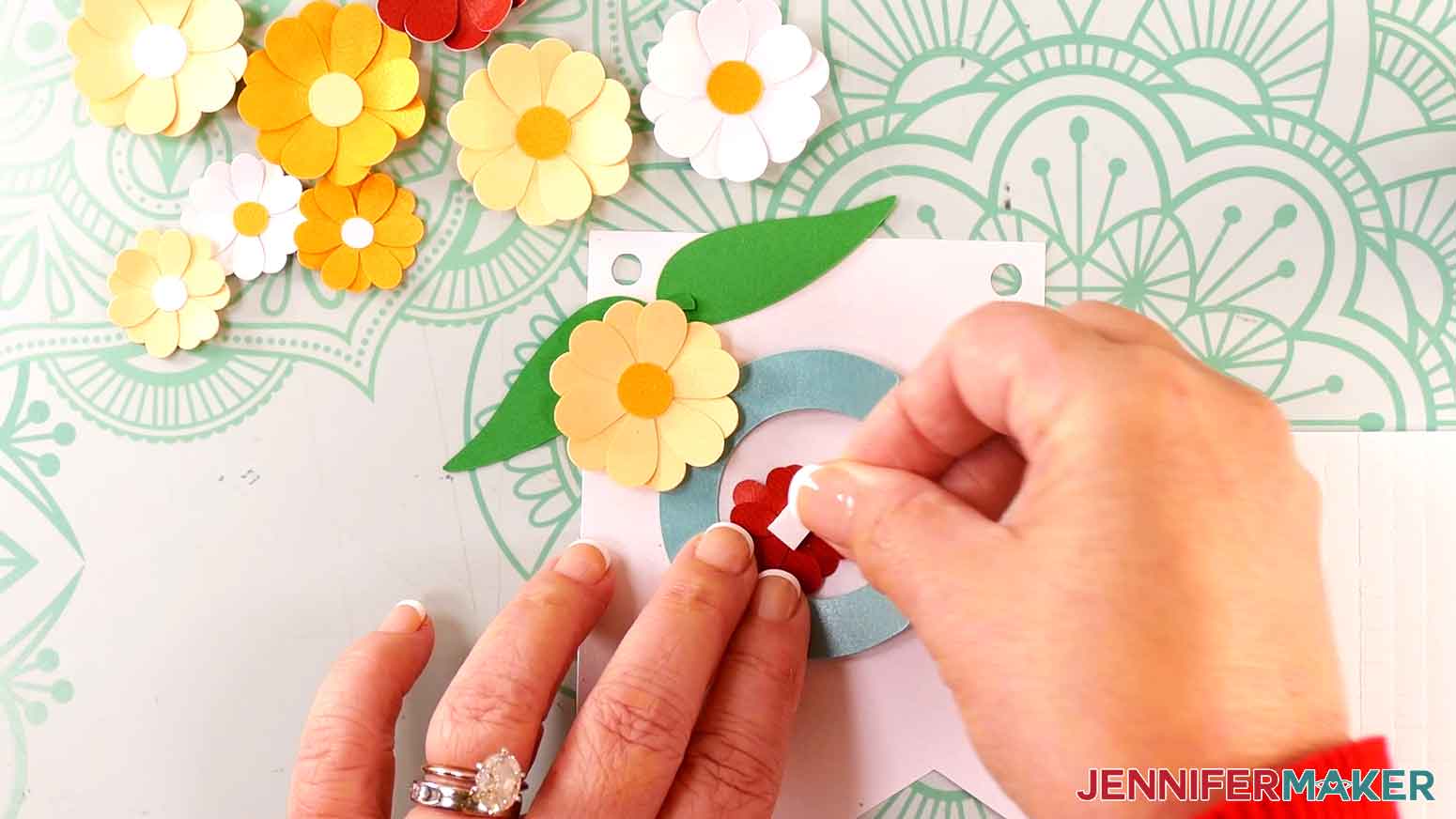 Place a foam adhesive square on the back of a red flower.