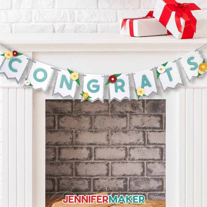 A Paper Bunting Banner spelling out "Congrats" hangs across a fireplace mantel with wrapped gifts on top.
