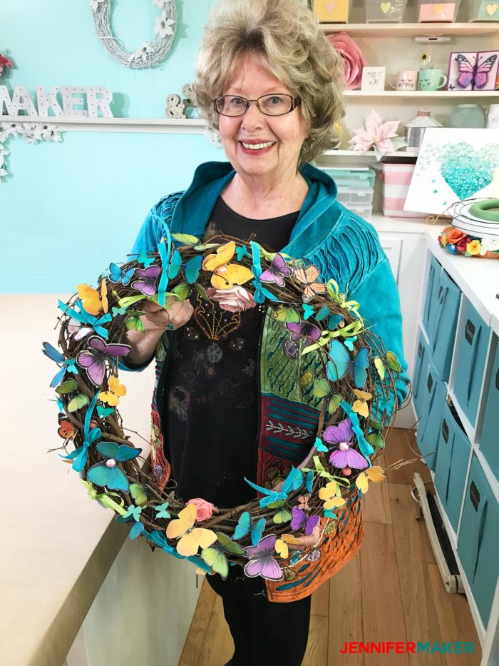 My mom holding her pretty paper butterfly wreath made with the Print Then Cut feature on the Cricut!