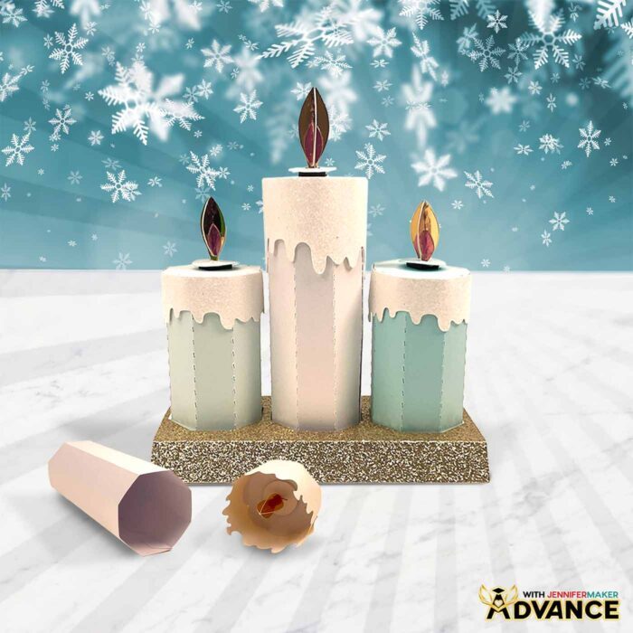 A trio of Paper Candle Gift Boxes sits on display with a glittery silver cardstock base. The candles sizes have been customized.