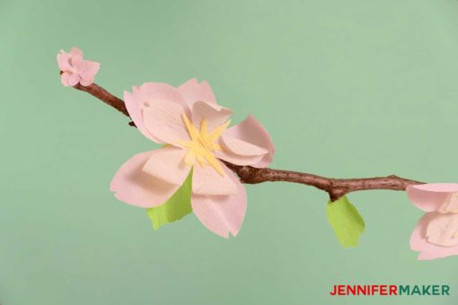 Crepe paper cherry blossom flower on a real branch