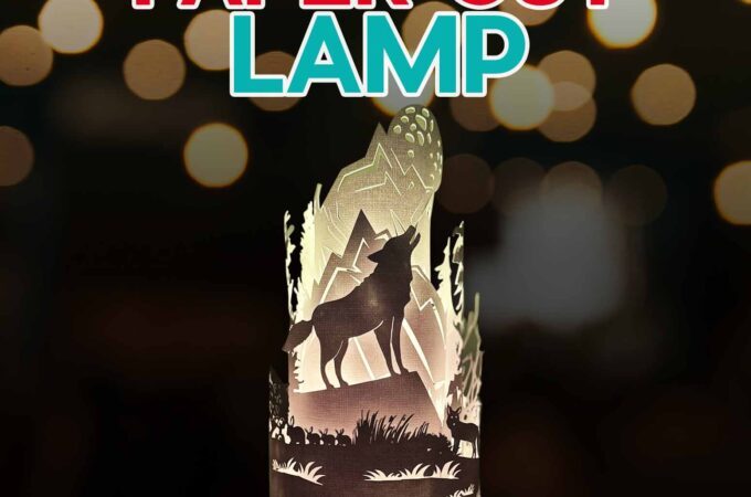 An illuminated paper cut lamp showing a wilderness wolf scene for a tutorial.