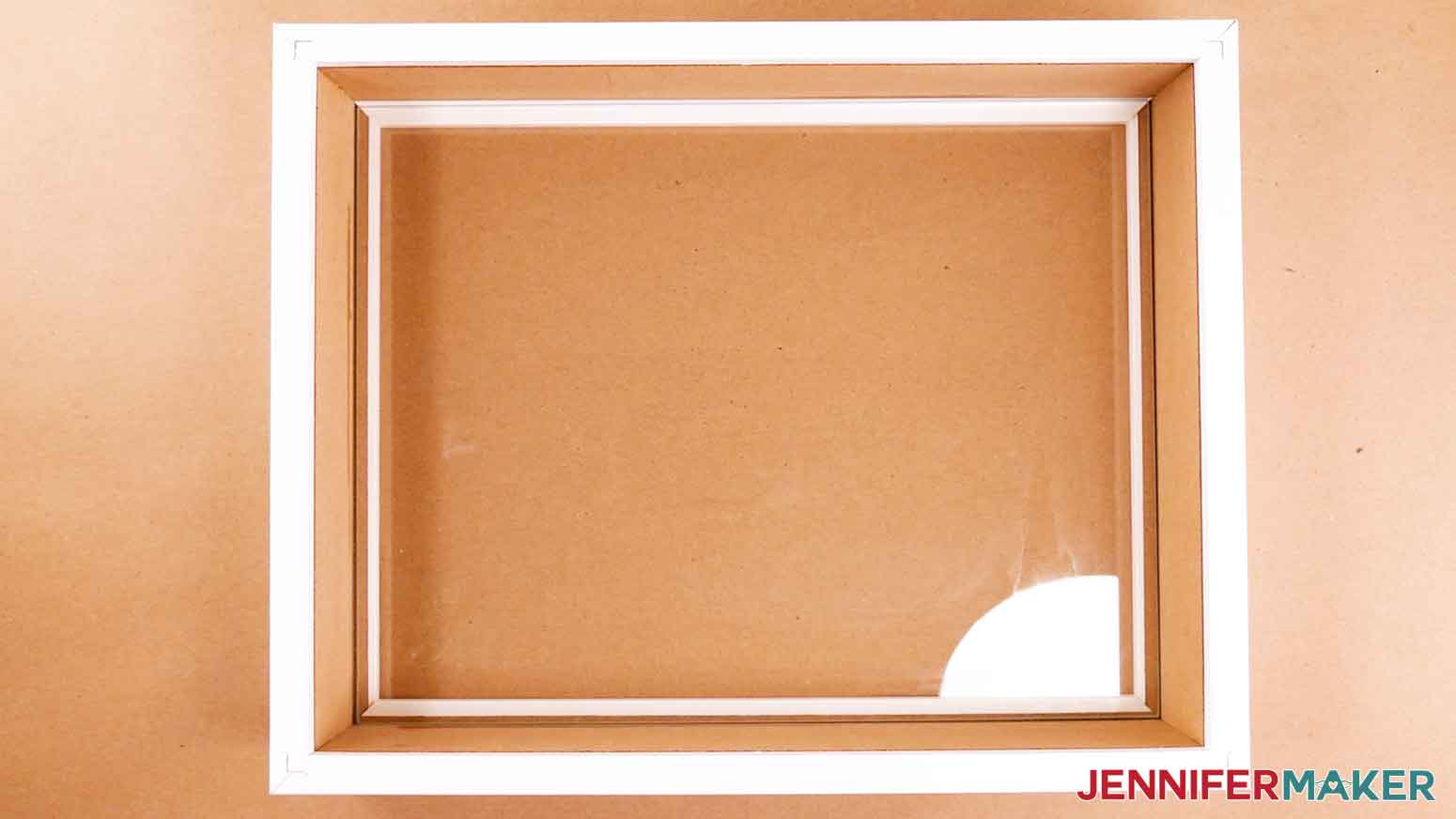 The purchased glass shadow box for the paper cut light box tutorial, showing the backing and inner wooden piece removed.