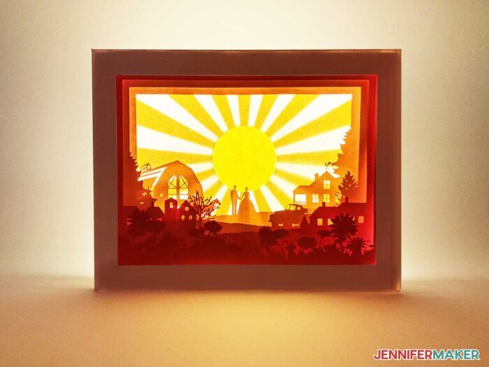 A finished paper cut light box with sunny layers inside a shadow box