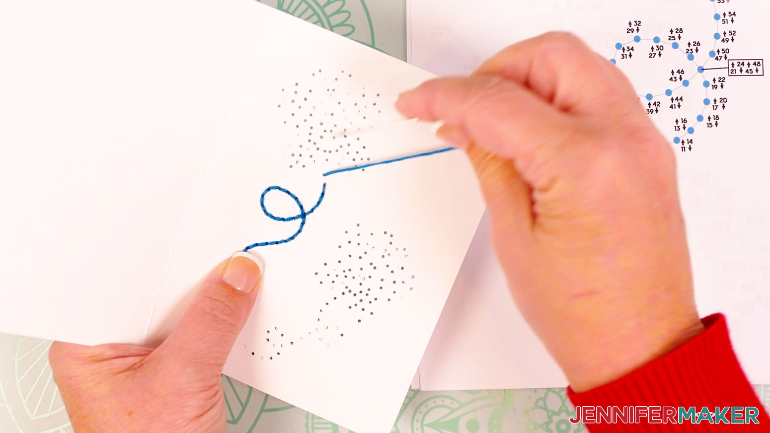 Continue with the blue embroidery floss to hole 56 and insert the needle down through the hole to complete the butterfly trail.