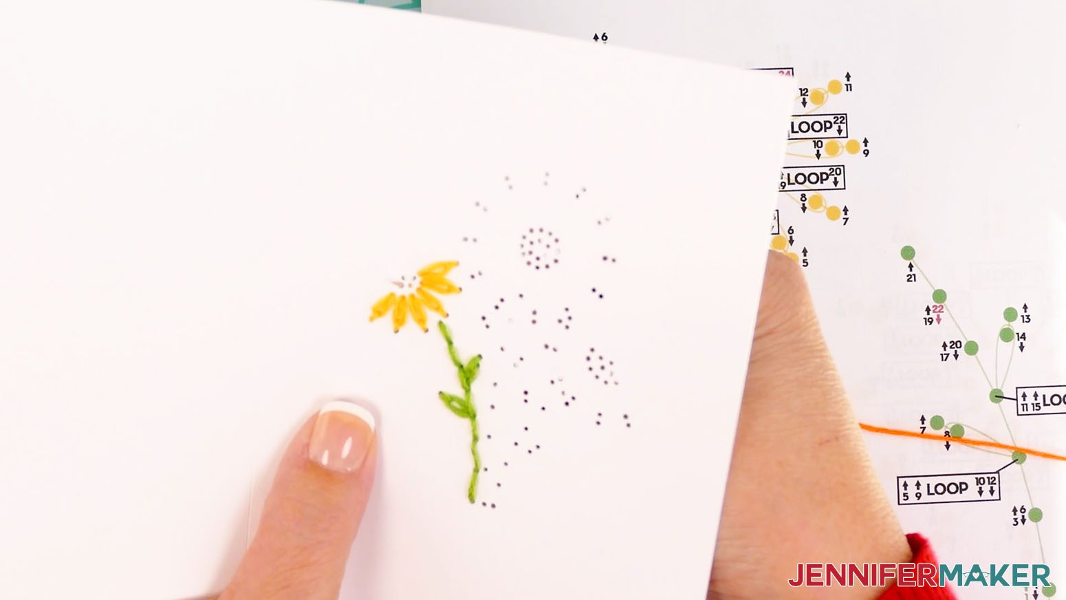 Bring the needle and orange embroidery floss up through hole one of the center of the left daisy.