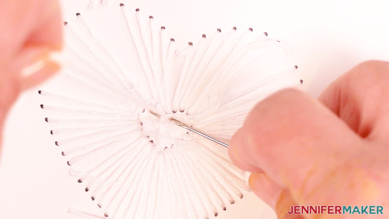 Use the needle to gently tighten the knot on the back of the card.
