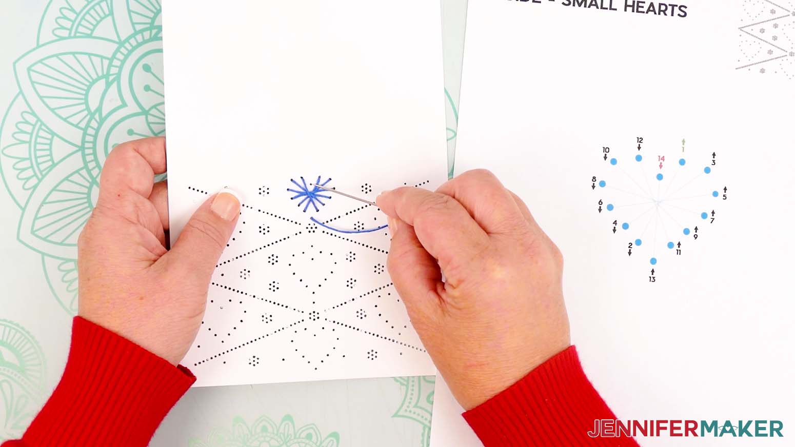Insert the needle down through hole 14 to finish the first small heart on the paper embroidery card.