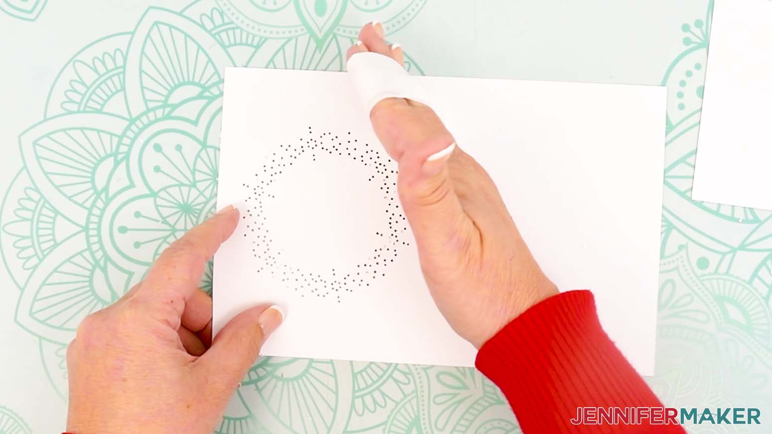 Use painter's tape to help grab the tiny hole cutouts to remove them from the card design.