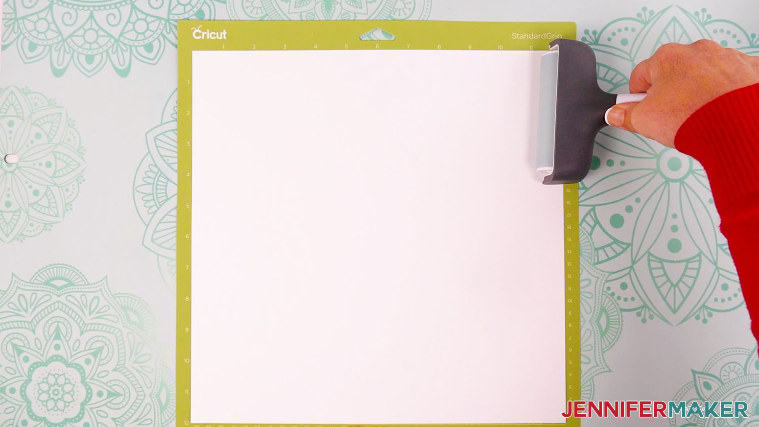 Use a brayer to fully adhere the white cardstock to the green machine mat.