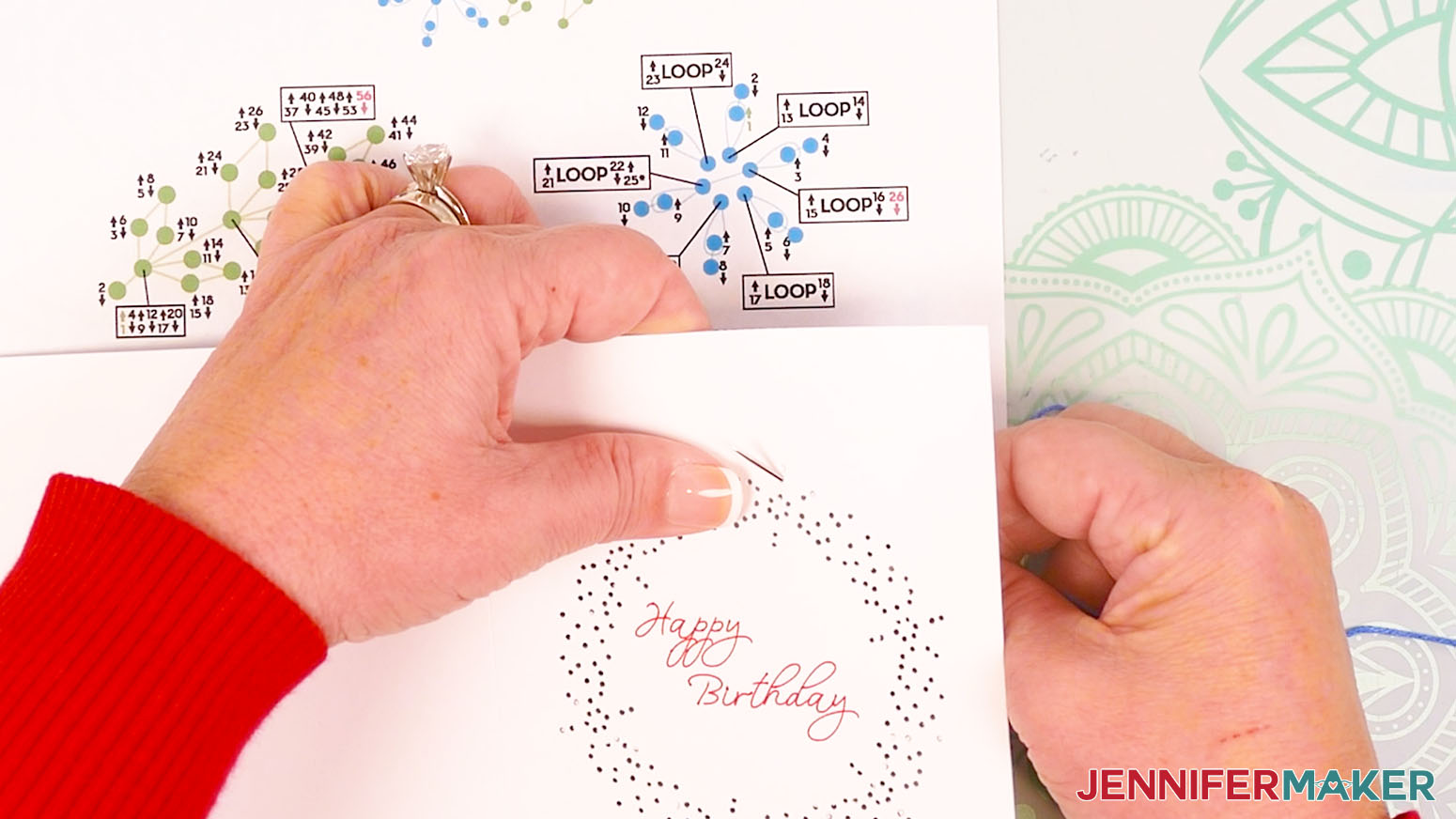 Insert the blue embroidery floss from behind the card up through hole one of the first flower.