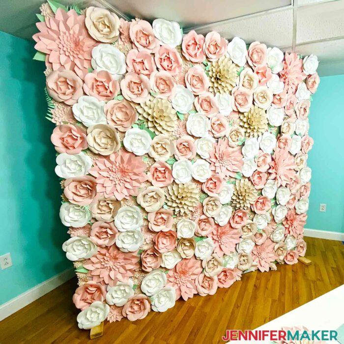 Completed Paper Flower Backdrop in pinks and creams in the corner of a teal room.