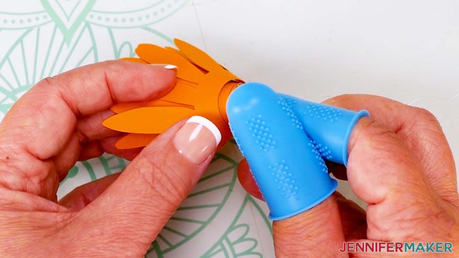 Apply hot glue to the circle tab and press it against the bottom of the flower.