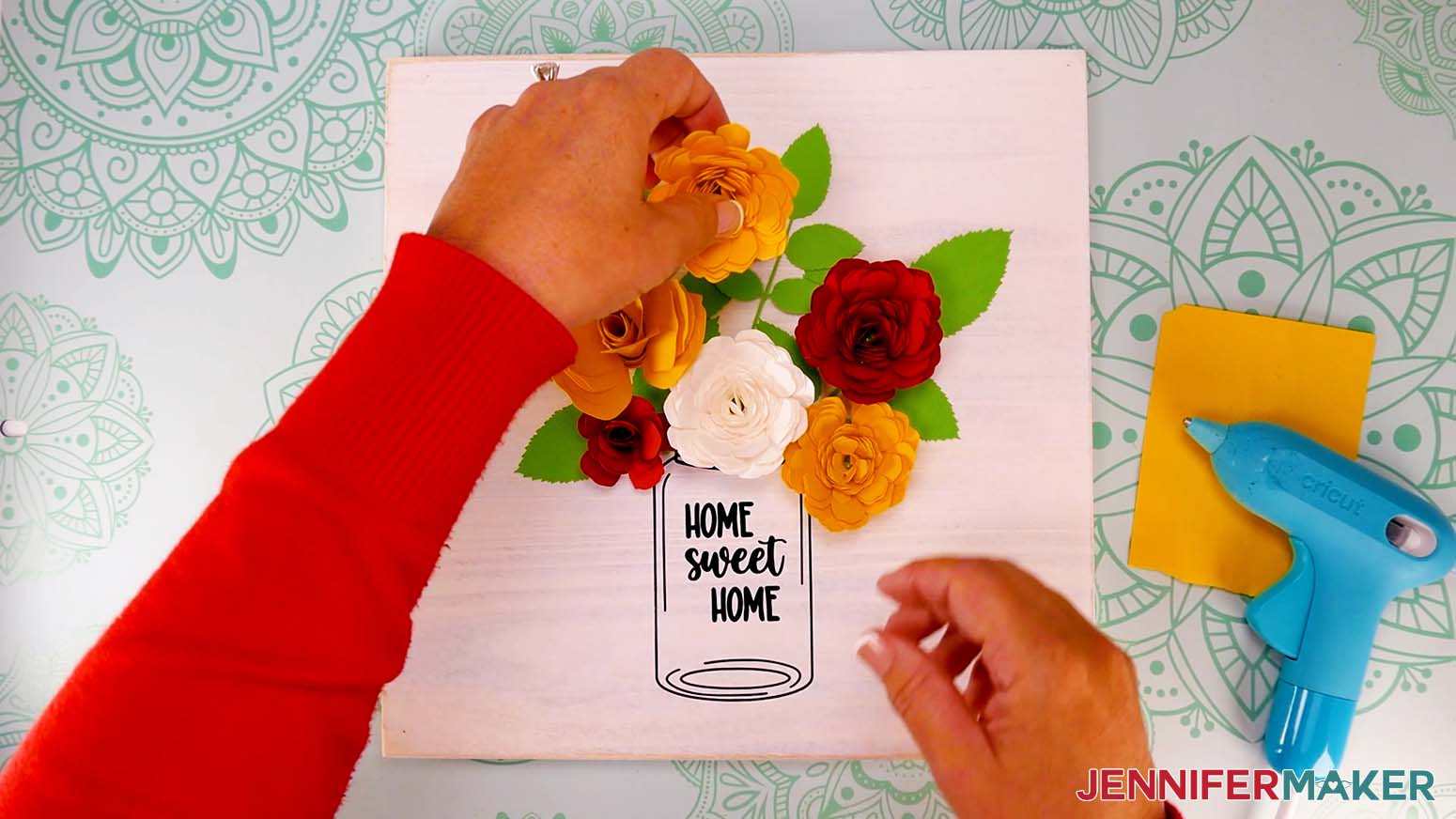 Arrange the flowers and leaves on the sign with the mason jar decal.